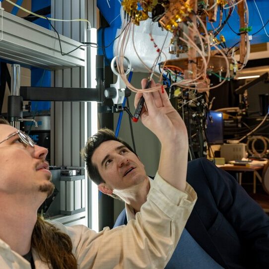 Two men working together on a large machine